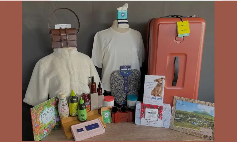 This photo shows several items of beauty and fashion including shirts, a photo frame and a pink luggage type box for storing items as well as for travel.