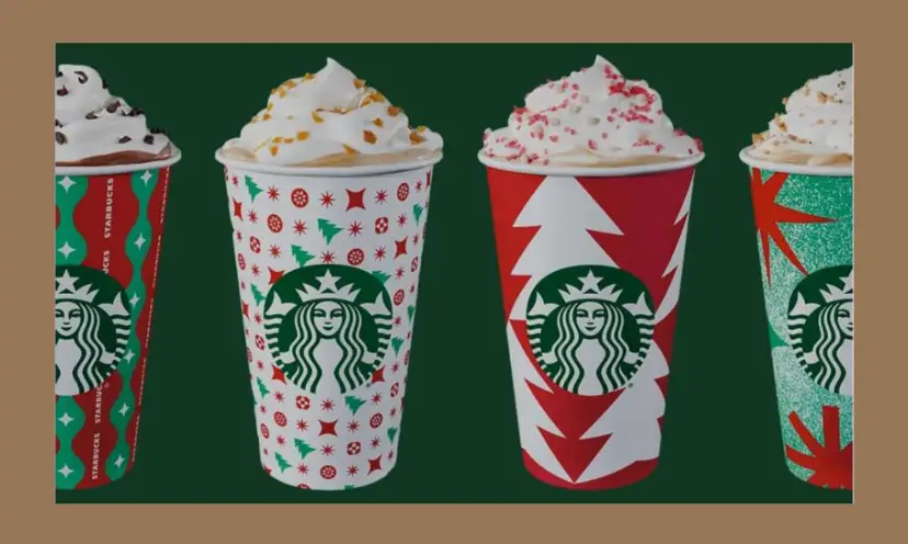 This photo features four festive Starbucks coffees topped with whipped cream and red sprinkles on top.