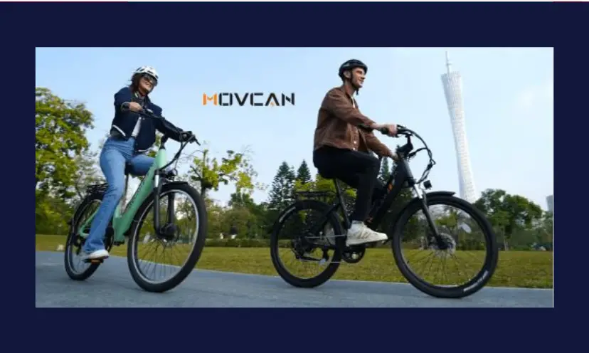 This photo shows a man and a woman each on an ebike. They are riding down a road with green leafy trees in the background. This image is branded with the name "MOVCAN" which is the bike brand.