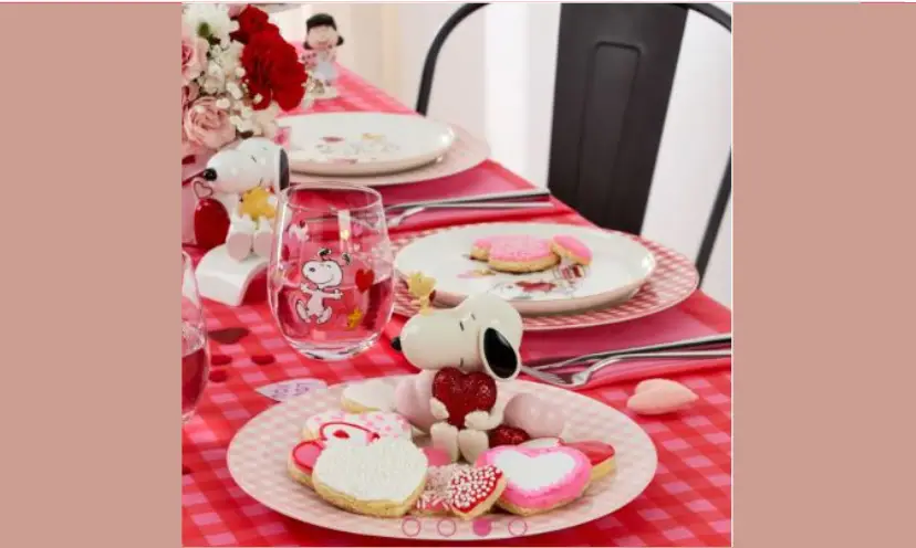 This photo show the prize you can win consisting of Snoopy themed Valentine dishes, figurines and flatware. The colors are predominately pink, red and white.