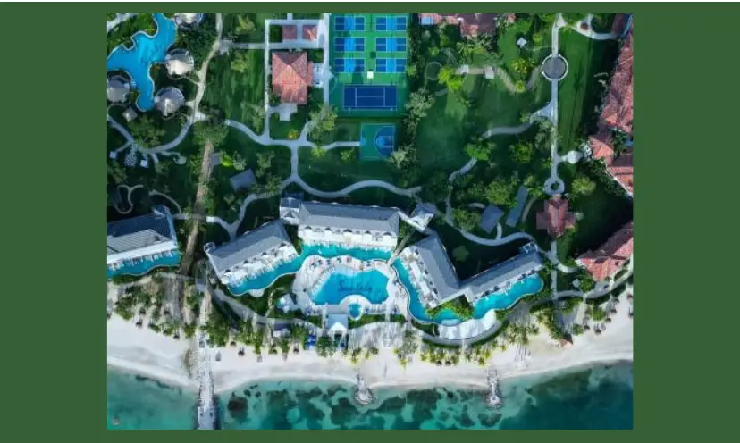 This photo is an aerial view of a Sandals resort including admentities and surrounded by white beaches and the tropical blue ocean!