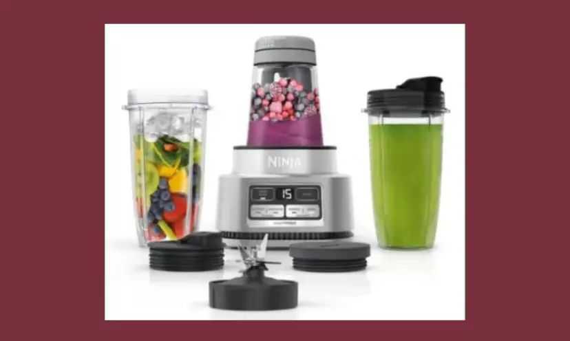 This photo features the Ninja smoothie bowl maker in this giveaway, It shows the blender and the accessories that come with it as they are filled with fruit, berries and other nutritious options!