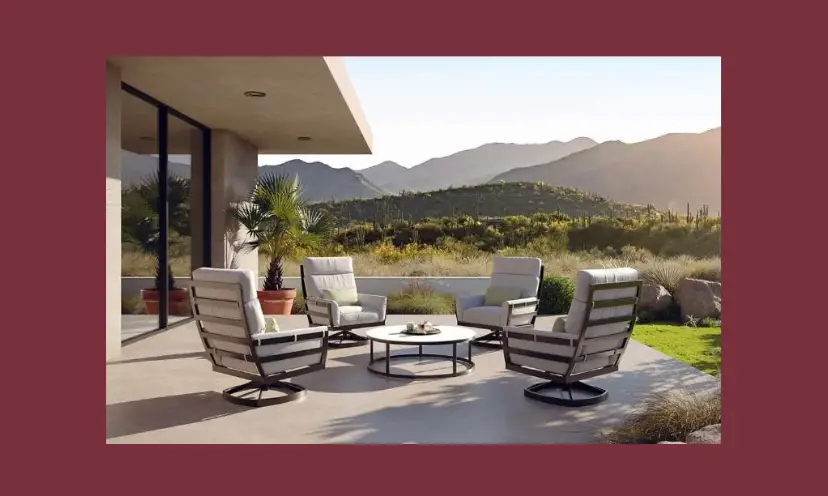 This photo features outdoor furniture complete with comfy cushions and a fire pit. It is placed on a patio with a backdrop of gorgeous mountains and trees.