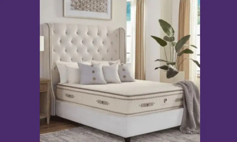 This photo features the luxurious mattress that you could win in this sweepstakes. The mattress is on a bed with a high back tufted headboard and the photo is surrounded by the tranquility of a purple background.