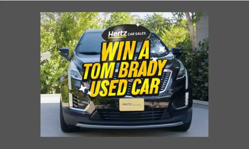 The caption in this photo says "Win a Tom Brady Used Car" and behind those words...is the beautiful black car in all its glory!