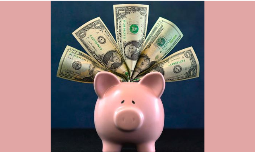 This is a photo of the idea of saving money...a pink piggy bank with dollar bills on their way in!
