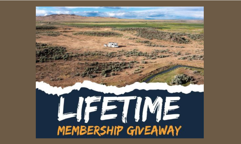 This photo features an RV in the distance on a serene and peaceful location...ready to set up for the night. The picture also shares the words: "Lifetime Membership Giveaway"!