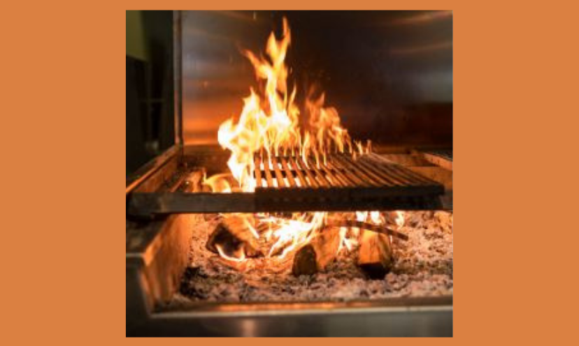 This is a close up photo of a wood fired grill. The flames, the wood and the warmth provided is captured in this excellent grill and the image here!
