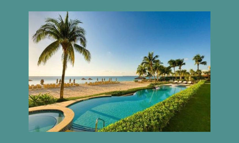 This beautiful photo features the beauty of the Cayman Islands...the destination of this sweepstakes. It is complete with palm trees, a beach view, a glistening blue pool and lots of sunshine!