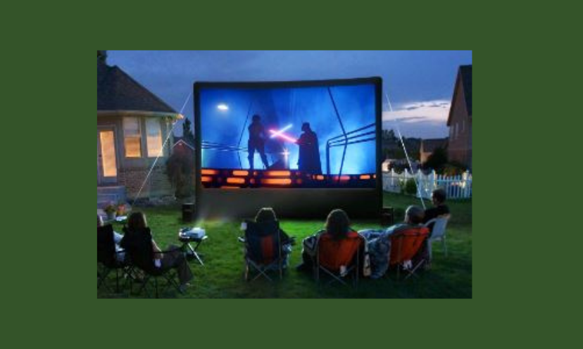 This photo is that of a backyard movie night...complete with projector and screen which are the prizes offered in this giveaway! A group of movie fans, friends and family are sitting comfortably and enjoying the big outdoor screen!