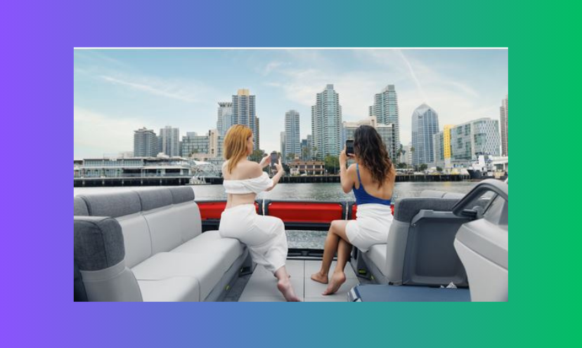 This photo features two young women enjoying the views from the plush seating aboard their day cruise. In the distance is of course the water, surrounded by a city skyline!
