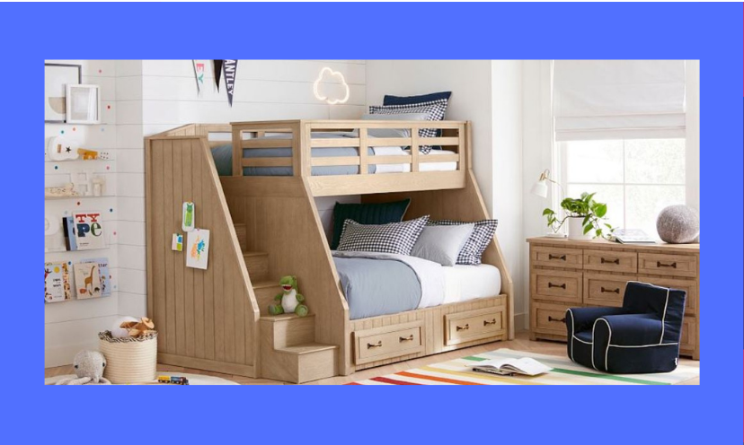 This photo is a sample of what Pottery Barn Kids has to offer, featuring a kids bunk bed with stairs, bedding, a handy matching nightstand and a super comfy side chair. It's the perfect space for kids to relax and call their own!