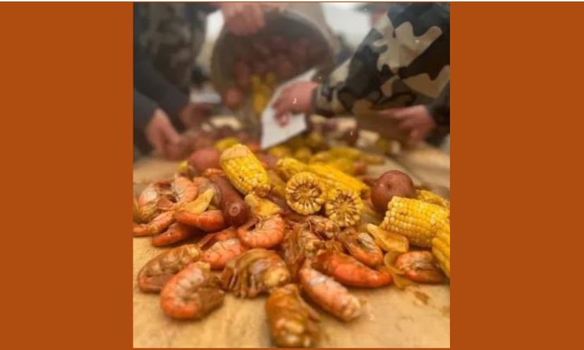 This is a photo of three fellas pouring a huge pot of boiled seafood on a table to serve an amazing feast...perfect for a tailgating party!