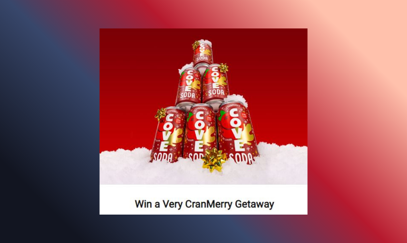 This is a photo of a stack of six festive cans of Cove soda, staying cold in the frosty snow. The caption says "Win a Very CranMerry Getaway"!