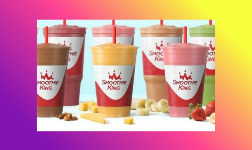 This photo is serving up images of multiple Smoothie King smoothie options. The colorful cups are surrounded by a sampling of nuts, berries, banana slices and more!