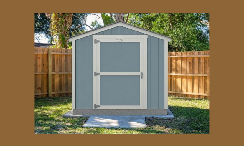 This is a photo of the handsome shed you could win in this giveaway. This version is blue with white trim. It is featured within a brown wooden fence on green grass...showing what an attractive storage addition looks like in your own backyard!