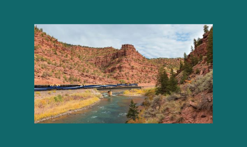 This photo features the railroad journey offered here with a red rock mountain backdrop and aqua colored water in the forefront!